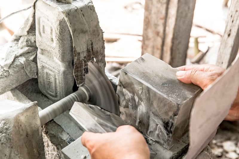 Craftsman Shaping Stone With A Saw